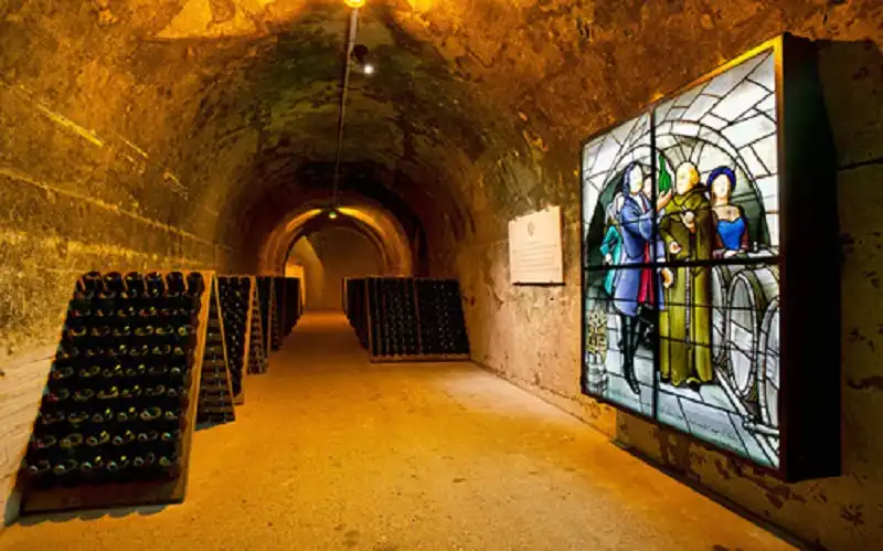 C6CJF4 Champagne bottles in pupitre, Taittinger champagne cellar, France
