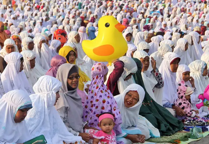 Lễ hội Eid al Fitr đánh dấu sự kết thúc tháng chay Ramadan 6 Muslim women attend an Eid al-Fitr prayer marking the end of the holy fasting month of Ramadan at Parangkusumo beach in Yogyakarta, Indonesia, Friday, July 17, 2015. (AP Photo/Slamet Riyadi)