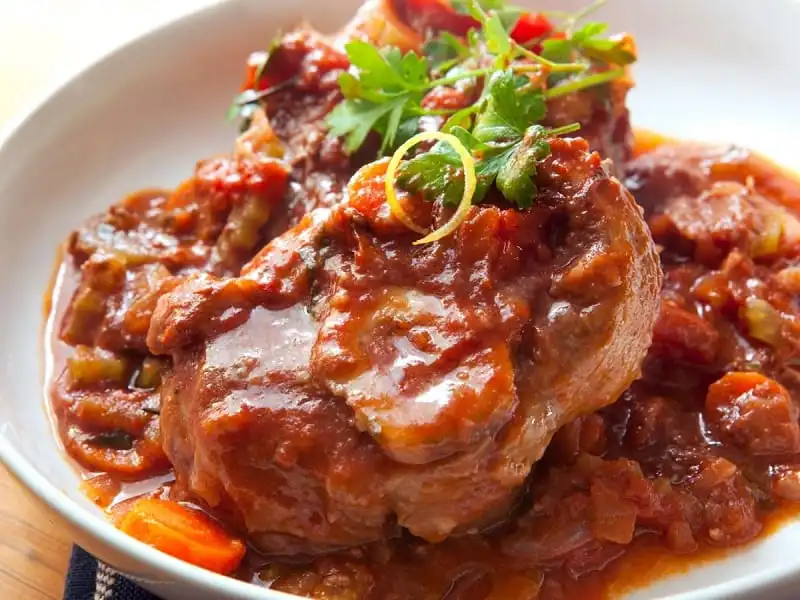 Ossobuco là món ăn nổi tiếng nhất của vùng Milan, sử dụng chân bê ninh kỹ cùng với cà chua, vỏ cam, cần tây và chút hạt tiêu Gia-mai-ca, thêm chút cà rốt, tỏi, rau thơm, rượu vang trắng và một số gia vị tổng hợp. Ossobuco không chỉ bắt mắt bởi màu vàng sánh của món ăn, độ béo ngậy trong từng khúc thịt mà nó còn hội tụ nhiều hương vị. Đó là vị ngọt đậm của xương và thịt hầm kỹ, thoảng hương thơm đặc trưng của hạt tiêu, vỏ cam.