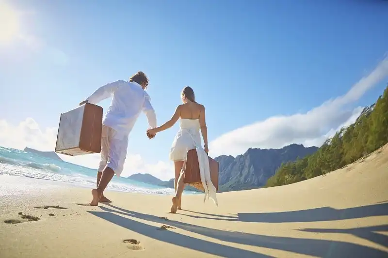 Mẹo đóng hành lý cho kỳ trăng mật 6 Caucasian couple with suitcases on tropical beach