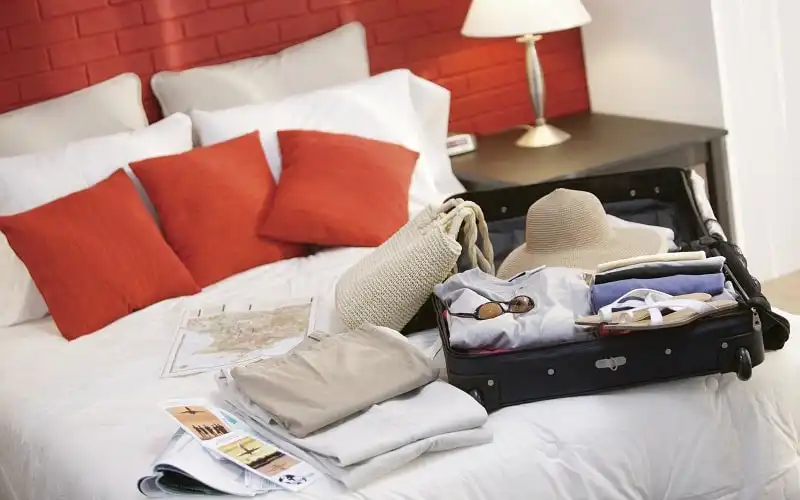 Mẹo đóng hành lý cho kỳ trăng mật 5 Woman's luggage and travel brochures on bed