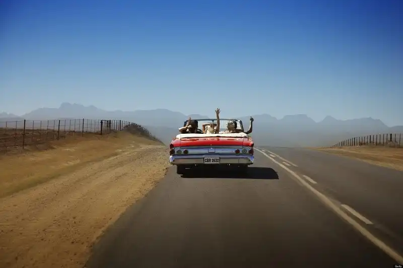 10 khẩu hiệu du lịch truyền cảm hứng cho những chuyến đi 2017 8 Five friends in convertible car, waving arms in air, rear view