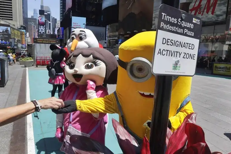 Chuột Mickey ở Quảng trường Thời Đại “móc túi” du khách 6 Costumed characters work in a color-coded designated activity zone in New York's Times Square, Tuesday, June 21, 2016. Street performers and costumed characters can be issued summonses or face arrest if they're caught operating outside the eight designated rectangles, under new rules aimed at controlling overly aggressive street performers. Each area is painted teal and measures 8 feet by 50 feet. (AP Photo/Richard Drew)