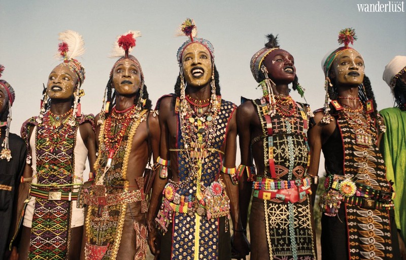 Các cuộc thi sắc đẹp để tôn vinh những người phụ nữ đã trở thành một phần trong văn hóa của nhân loại từ xa xưa cho đến nay. Thế nhưng hiện nay, tại cộng hòa Ni-giê vẫn còn lưu giữ lại lễ hội Gerewol – cuộc thi mỹ nam đặc sắc của những người dân bản địa. 
[rpi]
Hàng năm, cộng đồng những người bán du mục của bộ tộc Wodaabe tại tụ họp để tổ chức ăn mừng lễ hội Gerewol truyền thống. Gerewol, chính xác theo tiếng Ni-giê là Guérewol, được biết đến như một lễ hội bản địa đầy màu sắc và nhộn nhịp hiếm khách du lịch nào có cơ hội được tham gia. 
Nhiều người phụ nữ và trẻ em cưỡi trên những con bò có chiếc sừng vĩ đại, những người phụ nữ lớn tuổi thì đeo vô số vòng vàng khổng lồ ngồi trên lưng những con lừa, những cây cột màu sắc được dựng lên ở mọi nơi. Thế nhưng nhân vật chính của lễ hội lại là những người đàn ông của bộ tộc – những mỹ nam đến tham dự cuộc thi nam vương Gerewol. 
Gerewol ở đây là cuộc thi sắc đẹp chính hiệu, trong đó nam giới thay vì phụ nữ, sẽ ăn mặc, trang điểm và biểu diễn để thu hút bạn đời, tìm kiếm tình yêu và tiến tới hôn nhân. Những người đàn ông trẻ trong trang phục được trang trí cầu kỳ và trang điểm theo kiểu vẽ mặt truyền thống tụ tập thành hàng để nhảy và hát, tranh giành sự chú ý của những phụ nữ trẻ với mong muốn kết hôn.
Vẻ đẹp lý tưởng của nam giới của Wodaabe nhấn mạnh đến chiều cao, đôi mắt trắng và hàm răng. Vì vậy mà những người đàn ông thường trợn mắt và nhe răng để khoe ra những đặc điểm này của họ. Những người đàn ông sẽ xếp thành hàng và nhảy múa, mặt đối mặt với những đối tượng tiềm năng trong bảy ngày liên tục và nhiều giờ liên tiếp dưới ánh nắng sa mạc. Vì vậy, những người tham gia thường uống một hỗn hợp vỏ cây lên men, được tin là có tác dụng gây ảo giác, để duy trì sức nhảy trong khoảng thời gian kéo dài.  
Cộng hòa Ni-giê ở châu Phi là nơi nổi tiếng có khí hậu nóng và vô cùng khắc nghiệt, đặc biệt là trong mùa khô. Nước và đồng cỏ khan hiếm nên những người bán du mục Wodaabe di chuyển liên tục giữa các khu vực khác nhau, thường là vài ngày họ lại đi tìm nơi ở mới một lần. Vì vậy, Gerewol là thời điểm duy nhất tất cả người dân trong bộ tộc quây quần tụ họp lại với nhau trong năm. Tuy nhiên, nếu như thời tiết đang trong mùa mưa tồi tệ thì lễ hội có khả năng không được tổ chức. 
Lễ hội Gerewol được tổ chức ở bất cứ đâu mà những người trong bộ tộc Wodaabe xuất hiện, nơi nổi tiếng nhất là vùng In-Gall ở phía tây bắc Ni-giê. Tại đây bên cạnh cuộc thi mỹ nam truyền thống còn diễn ra hội chợ và hàng loạt các hoạt động văn hóa khác, trong đó có sự kiện khiêu vũ Yaake. Ngoài ra, đây là dịp để trao đổi của hồi môn, tổ chức cuộc đua lạc đà giữa những người cầu hôn, khiến cho sự kiện này có thể kéo dài tới cả tuần lễ. 
