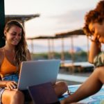 Girls on beach on laptops